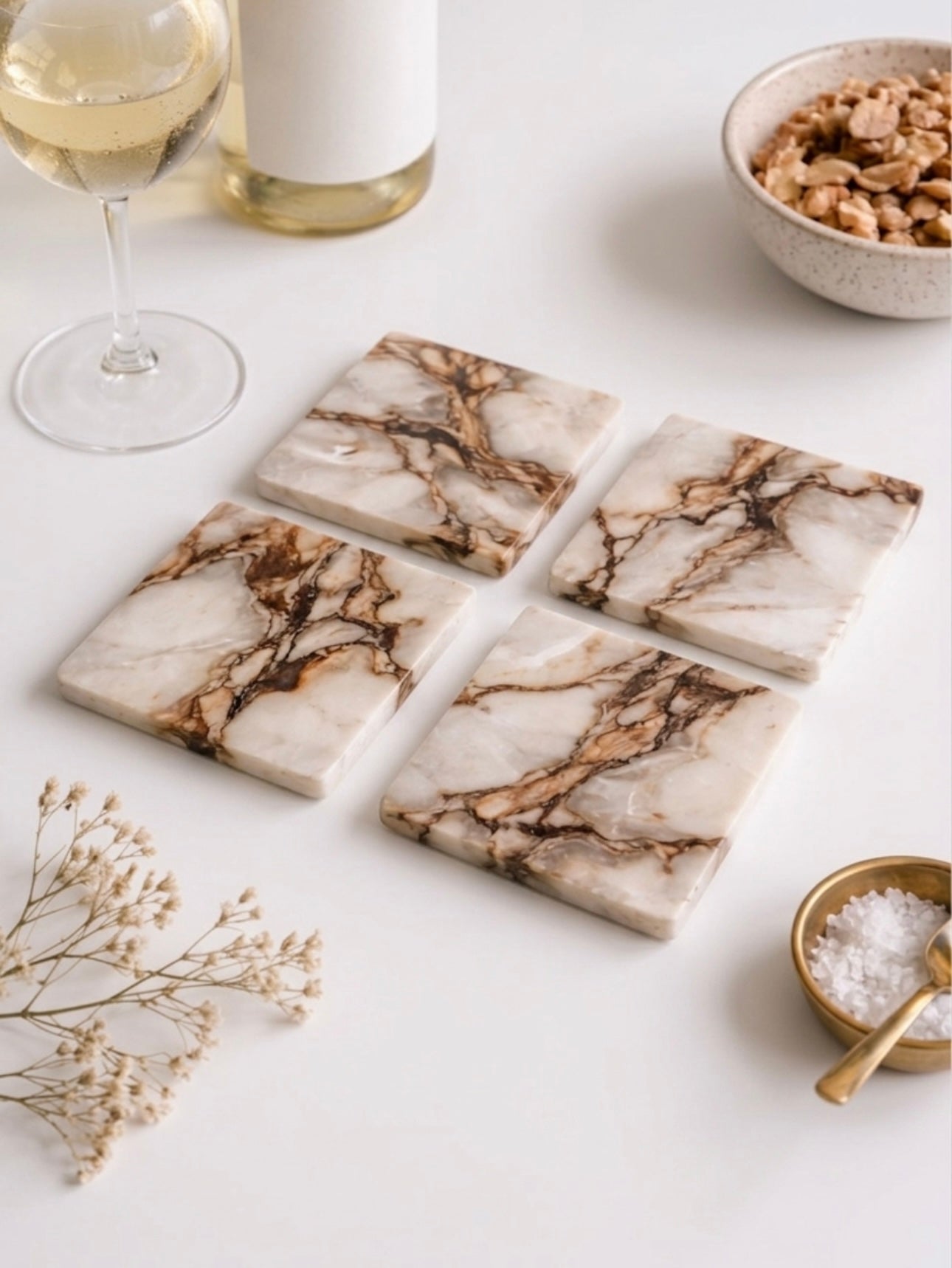 Vyasaara - Marble-patterned coasters on a white surface with a glass of wine and bowl of nuts.